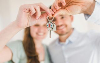 couple qui tient un porte-clé maison